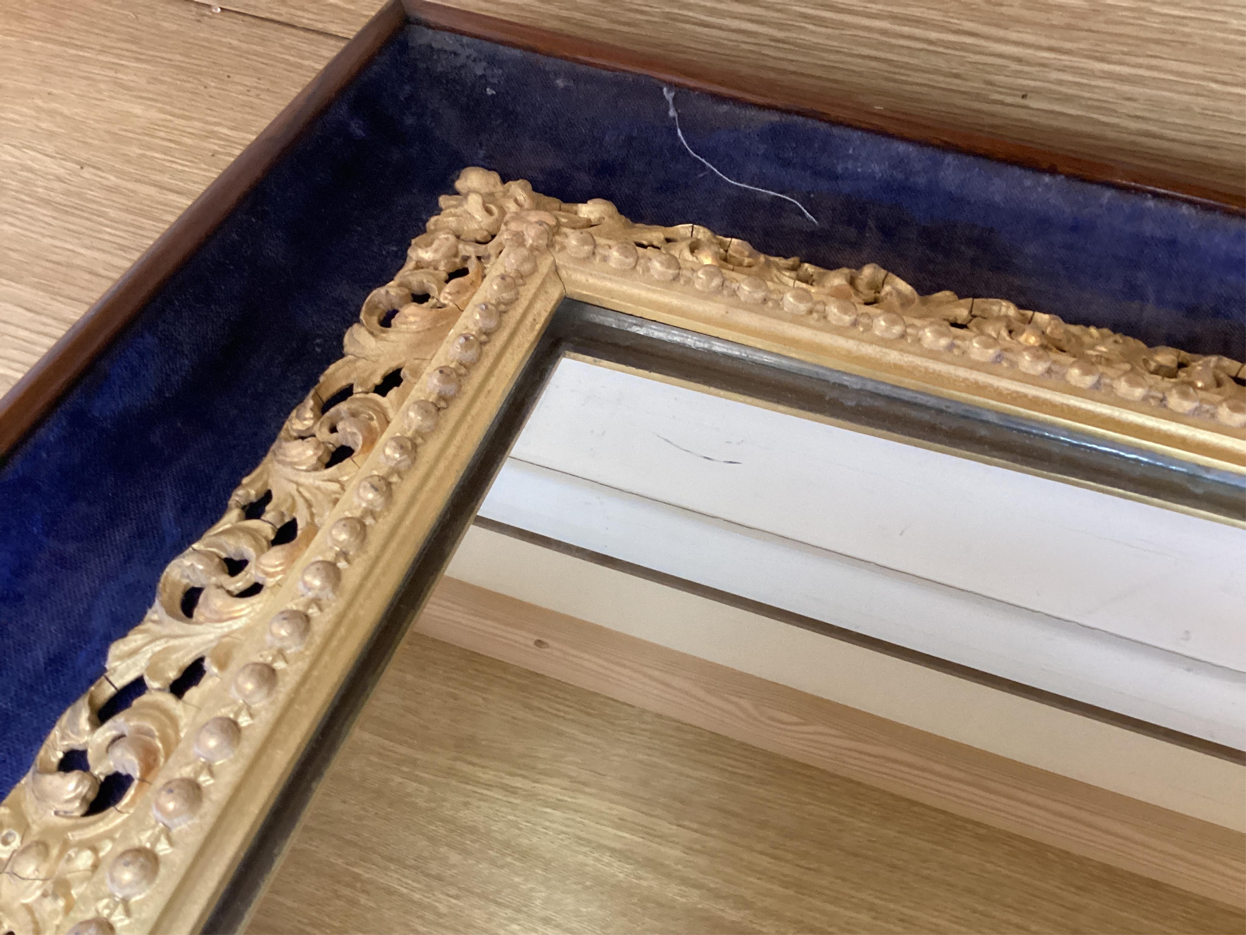 A 19th century carved gilt wood framed mirror, displayed within a blue velvet mount and outer rosewood frame, 48cm wide x 56cm high